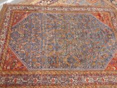 Middle eastern red ground bordered carpet with central blue panel decorated with kingfishers and flo