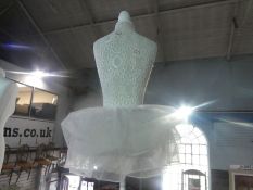 A white painted mannequin with a tutu