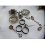 A lot of silver items to include ash tray, silver trinket dishes, napkin rings, spoons and a decorat