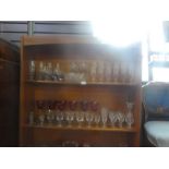 A mid century teak open bookcase above panel cupboards