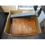 A box containing postcards albums, loose postcards of various themes