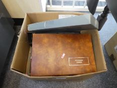 A box containing postcards albums, loose postcards of various themes