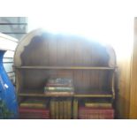 A vintage oak kitchen dresser with arched open shelves above drawers and cupboards