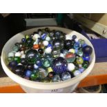 Container containing various vintage marbles