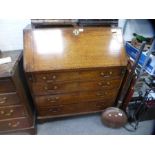A 19th century oak fitted bureau above four drawers and bracket supports