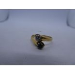 18ct yellow gold crossover design ring with a crossing sapphire and diamond, marks worn, approx 0.20