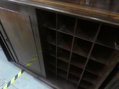 A large mahogany glazed bookcase above slide cupboard with fitted interior