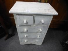 A small painted bedside chest of drawers and a fire screen