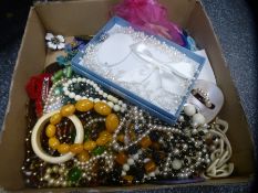 A box of costume jewellery to include beaded necklaces, brooches, clip on earrings, bangles, shell-l