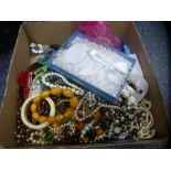 A box of costume jewellery to include beaded necklaces, brooches, clip on earrings, bangles, shell-l