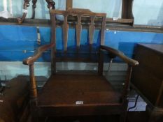 An antique mahogany tilt top table and an oak armchair