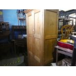 A Victorian wax pine two door paneled wardrobe