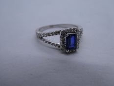 Pretty 18ct white gold halo ring with central princess cut sapphire set in split shoulder diamond in