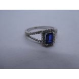 Pretty 18ct white gold halo ring with central princess cut sapphire set in split shoulder diamond in