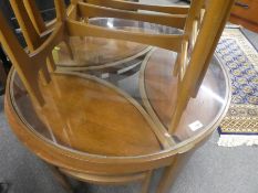 A 1960s G plan circular glass top table with three nesting tables