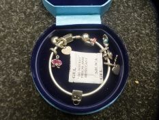 A Pandora bangle hung with a number of charms