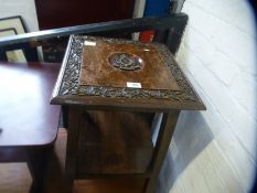A square mahogany two tier coffee table with carved insignia for the Lancashire Fusiliers