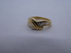 18ct yellow gold crossover design ring with tapered baguette cut diamond to shoulder, marked 750, ap