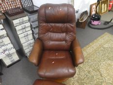 Brown leather "Stress less" revolving arm chair and footstool