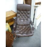 A 1970's style brown leather buttonback armchair on swivel base