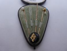 Three Victorian yellow metal stick pins in fitted case 'Collingwood & Sons' two hung with pearls, pi