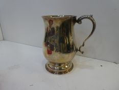 A heavy silver tankard on a raised pedestal foot with decorative leaf handle, hallmarked Birmingham