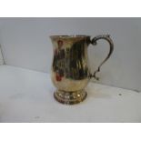 A heavy silver tankard on a raised pedestal foot with decorative leaf handle, hallmarked Birmingham