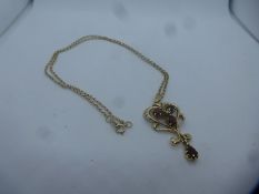 9ct floral design garnet set pendant hung on a 9ct yellow gold chain