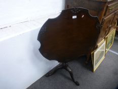 A Georgian style mahogany tripod table having shaped top with carved decoration