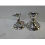A pair of silver candlesticks hallmarked Birmingham 1916 W H Haseler Ltd. 9cm high approx with decor