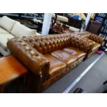 Two similar modern tan leather Chesterfield sofas, the largest 210 cms