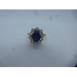 18ct yellow gold sapphire and diamond cluster ring, a central oval sapphire surrounded by 10 0.05 ca