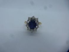 18ct yellow gold sapphire and diamond cluster ring, a central oval sapphire surrounded by 10 0.05 ca