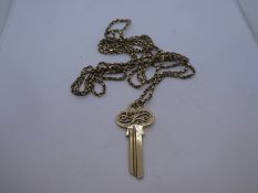 9ct yellow gold pendant in the form of a key, approx 5.5cm marked 375, hung on a yellow metal chain,