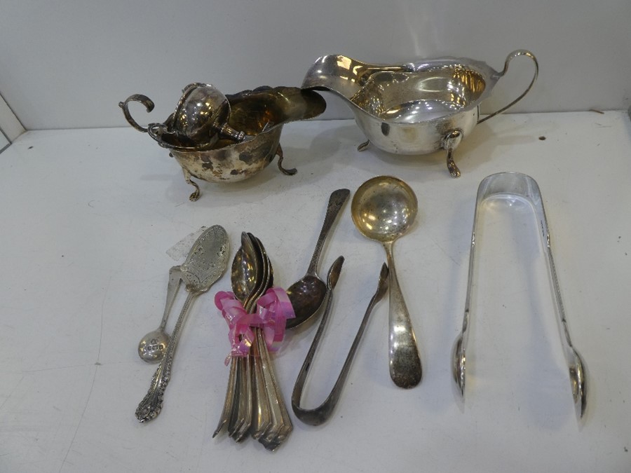 A large mixed lot of silver items to include a gravy boat, trophy, cutlery, etc. Total gross weight
