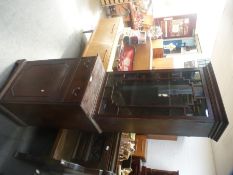 An early 20th Century mahogany pillar display cabinet having one drawer with cupboard below