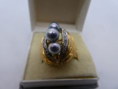 18K gold ring designed in the form of a walnut with three central purple pearls flanked by a row of