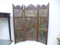 An Arts and Crafts style folding fire screen having eight copper panels decorated with birds and dee