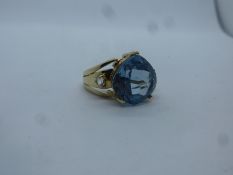 Contemporary 9ct yellow gold dress ring inset with large pale blue stone and clear circular stones t
