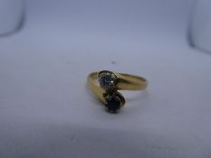 18ct yellow gold crossover design ring with a crossing sapphire and diamond, marks worn, approx 0.20