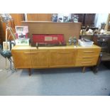 A 1970's teak sideboard having cupboards and drawers, 199cms