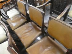 A set of four tan leather and button upholstered dining chairs