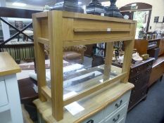 A modern oak hall table having one long drawer with glass shelf below