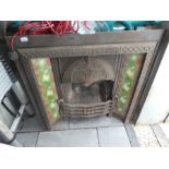 Victorian fireplace with floral green tile inserts and a decorative hood
