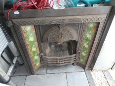 Victorian fireplace with floral green tile inserts and a decorative hood