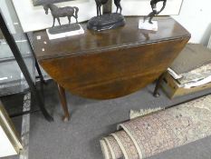 An antique oak two flap dining table having one drawer on pad feet