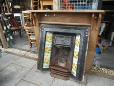 Cast iron fire insert with floral side tiles, ornate insert and wooden fire surround