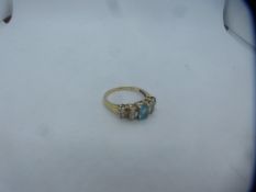 9ct yellow gold dress ring set with central oval aquamarine surrounded by diamond chips, size P/Q, m