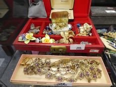 Red leather jewellery box containing mixed costume jewellery including brooches, necklaces, earrings