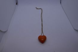 Orange hardstone heart design pendant hung on unmarked yellow metal box chain